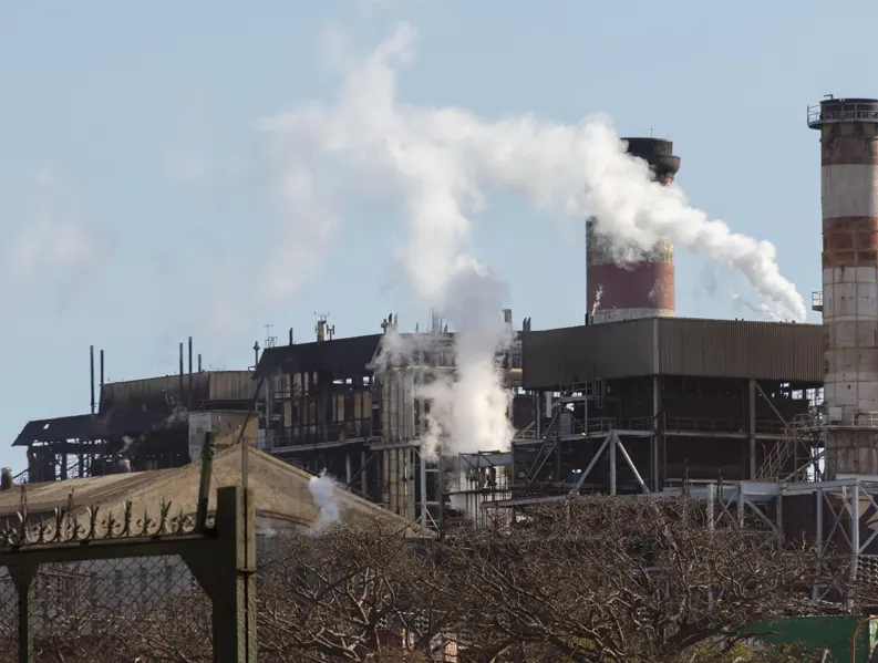 A factory with smoke coming out of the chimney having air pollution controll