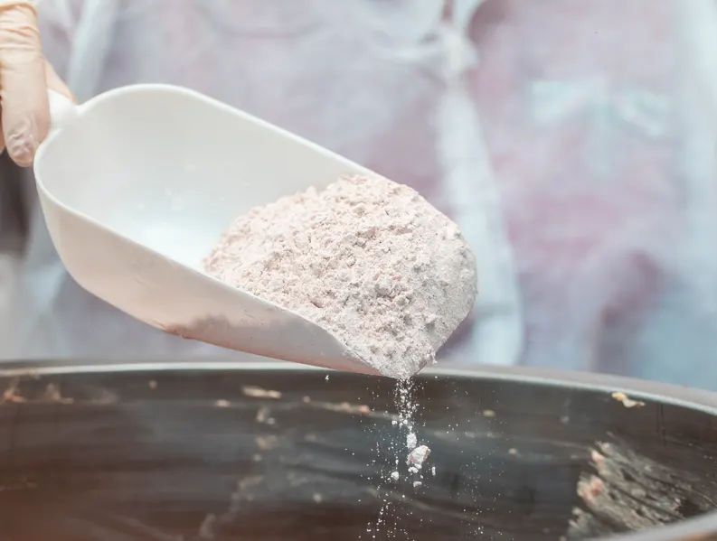 A person pouring grinded powder into a bowl